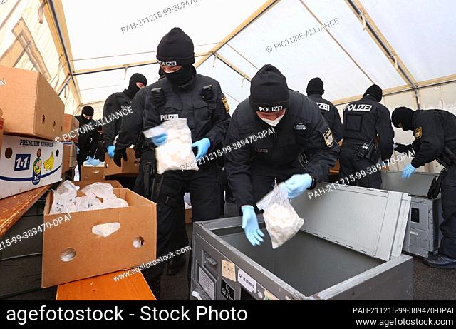 14 December 2021, Bavaria, ---: Bavarian riot police officers prepare bags of cocaine for removal. As part of Operation Snowmelt