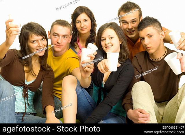 Group of 6 teenagers sitting together. They're holding plastic cups and look like have party. White background