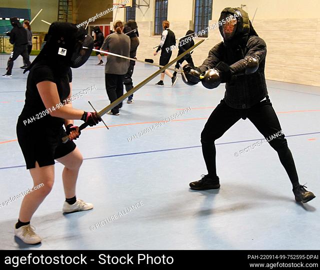 08 September 2022, Saxony, Leipzig: Historical fencing with long swords is practiced in a gymnasium by men and women under the guidance of fencing instructor...