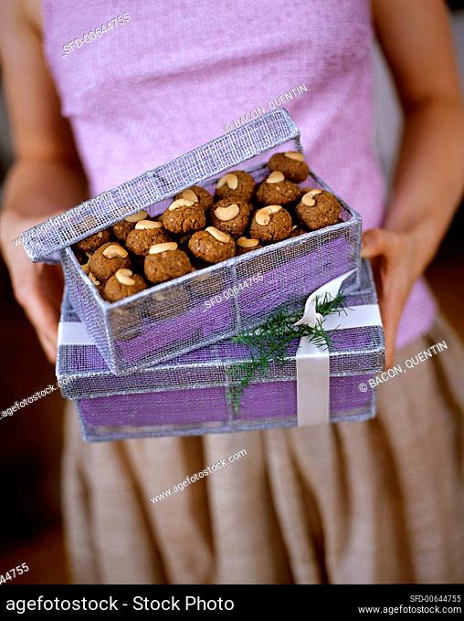 A Woman Holding Gift Boxes with Cashew Spice Cookies