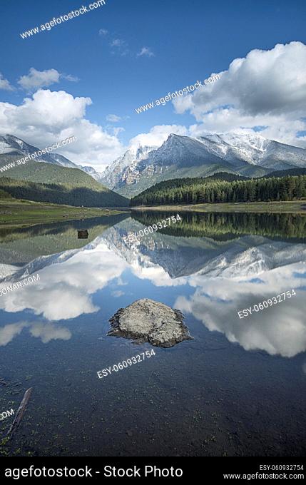 The calm still water of Mission reservoir and high peak snow covered mountains near St. Ignatius, Montana
