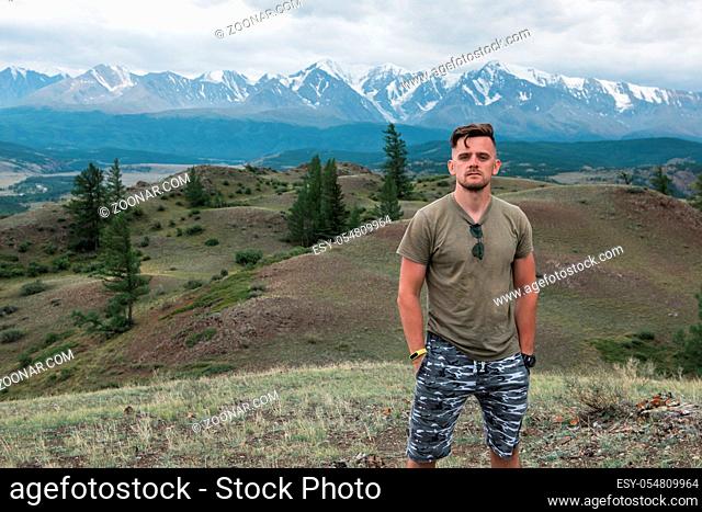 Relaxing man in Kurai steppe on North-Chui ridge background. Altai mountains, Russia
