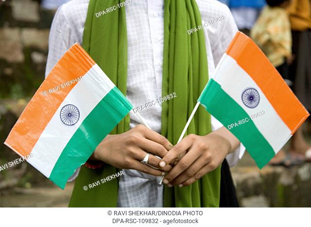 Boy holding two Indian tri-color Flag in the hand on Independence day celebration at 15th August ; Village Delwara ; Udaipur ; Rajasthan ; India