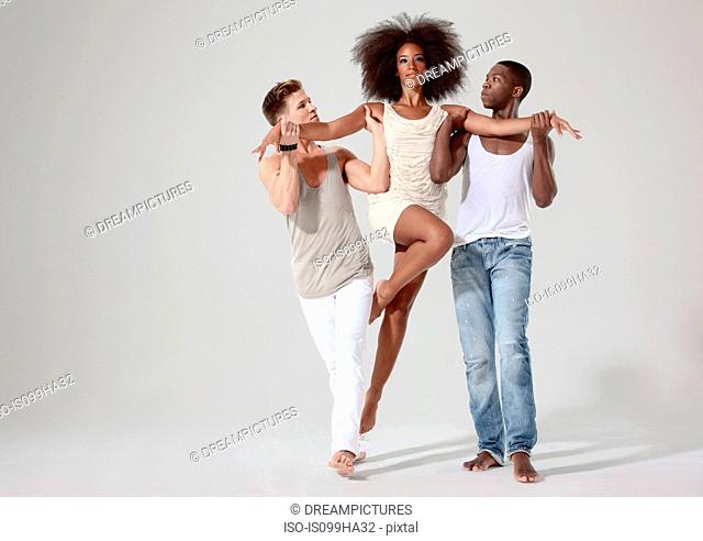 Two men holding a young woman off the ground