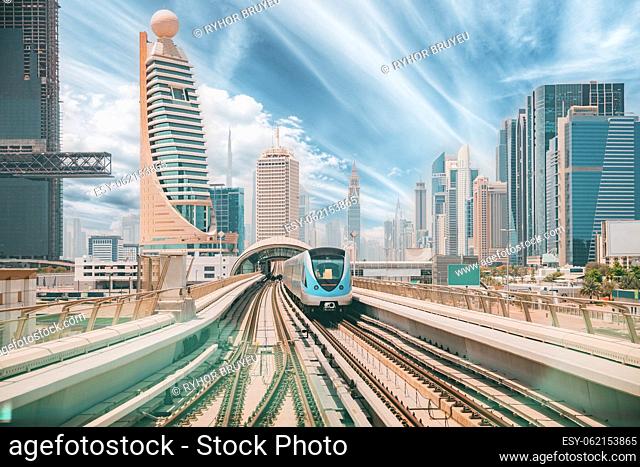 Monorail Subway train rides among glass skyscrapers in Dubai. Traffic on street in Dubai. Cityscape skyline. Urban background