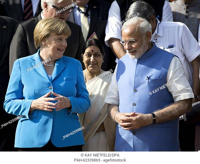 German chancellor Angela Merkel and Indian Prime Minister Narendra Modi pose on the red carpet on the stairs to the Hyderabad House for a group picture after...