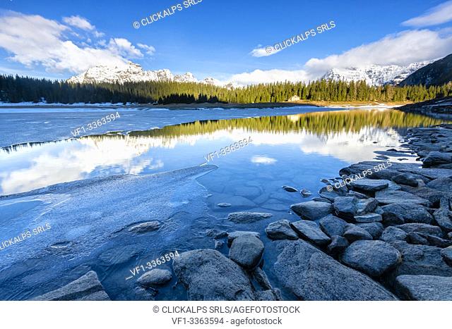 Sunrise over Lake Palù partially frozen during thaw, Malenco Valley, Sondrio province, Valtellina, Lombardy, Italy