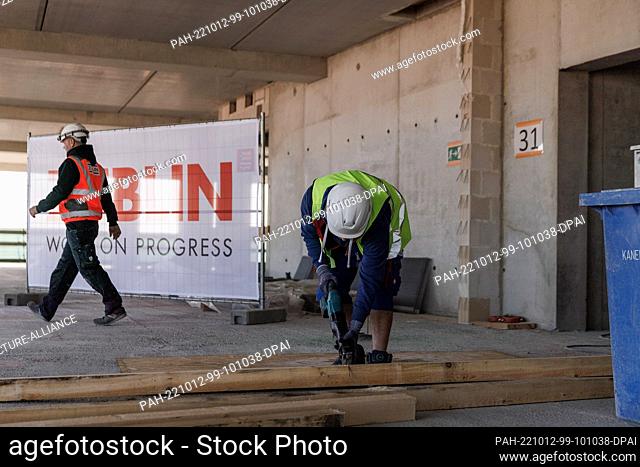 12 October 2022, Berlin: A craftsman works on the construction site on the 31st floor of Edge East Side Berlin before the topping-out ceremony