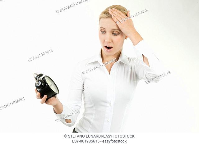 Businesswoman looking shocked at the clock