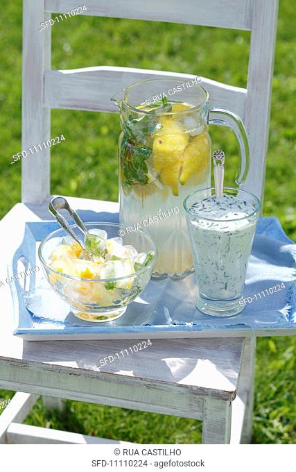 Lemonade, a cucumber and dill drink, ice cubes with orange zest and herbs