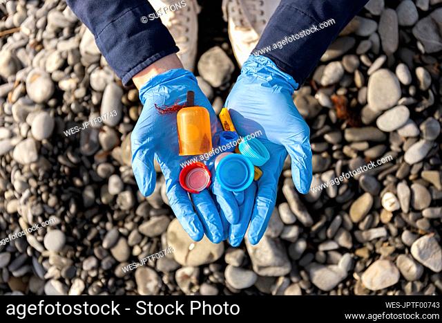 Woman in protective glove holding plastic cap