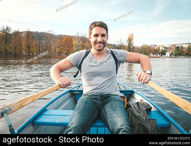 happy smiling man rowing on the river