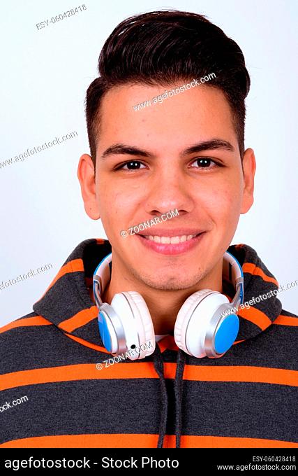 Studio shot of young handsome multi ethnic man wearing hoodie against white background