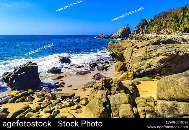 Blue turquoise water and extremely beautiful huge big surfer waves rocks cliffs stones mountains and boulders on the beach in Zicatela Puerto Escondido Oaxaca...