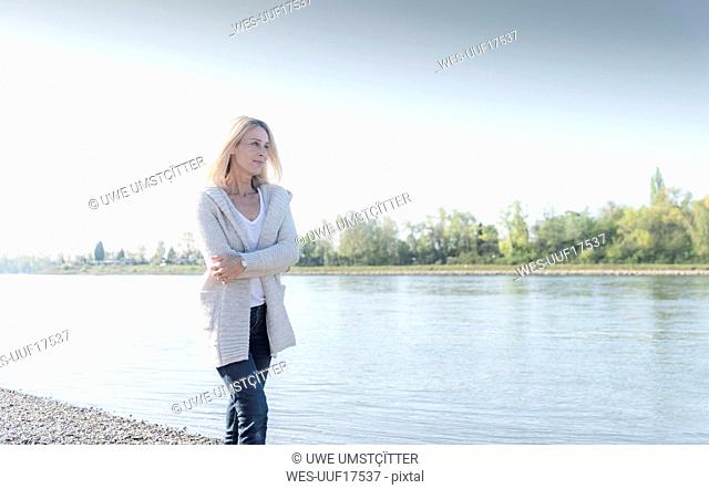 Smiling mature woman walking at the riverside