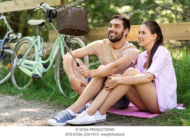 couple with bicycles taking selfie by smartphone
