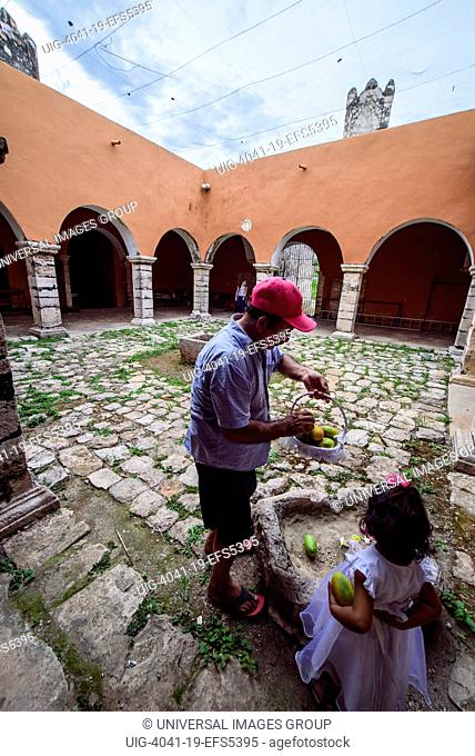 Father and daughter collecting fruits in the convent of Mama, Yucatan, Mexico