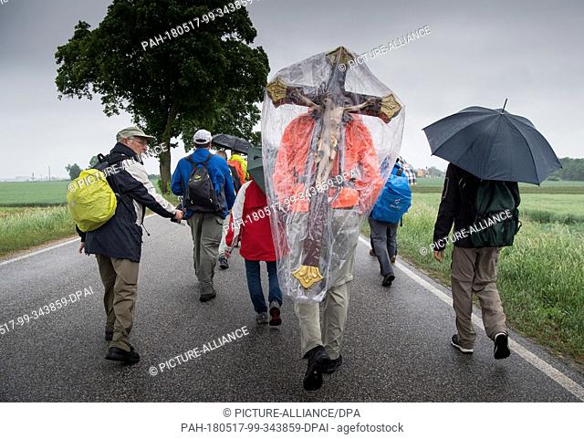 17 May 2018, Germany, Niedertraubling: A pilgrim carrying a wooden cross on his back. The pilgrims are set to walk 111 kilometres from Regensburg to Altoetting...