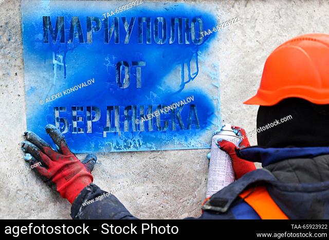 RUSSIA, ZAPOROZHYE REGION - DECEMBER 19, 2023: An employee applies a sign reading ""From Berdyansk To Mariupol"" onto a reinforced concrete structure at a plant...