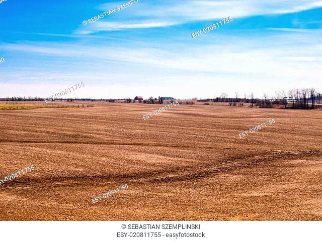 Empty brown farm fields on sky