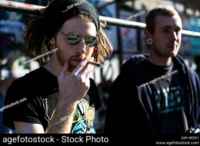 Cannabis smokers and activist puff lots of joints at the 420 Weed Day at Freetown Christiania in Copenhagen: here a guy with dreadlock and sunglasses