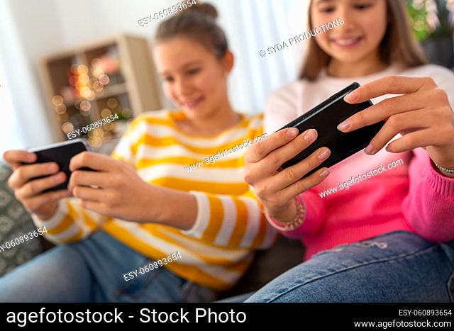 happy teenage girls with smartphone at home