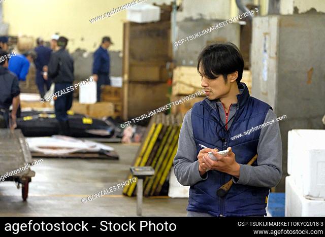 Japan, Tokyo – March 27, 2018: A man seen at work at the tuna auction in Tsukiji