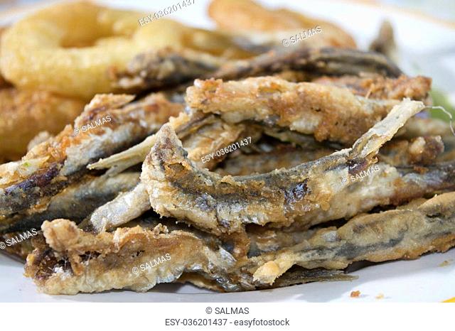 fish fry with a dish of floured and fried anchovies