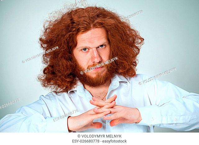 The young man with long red hair looking at camera
