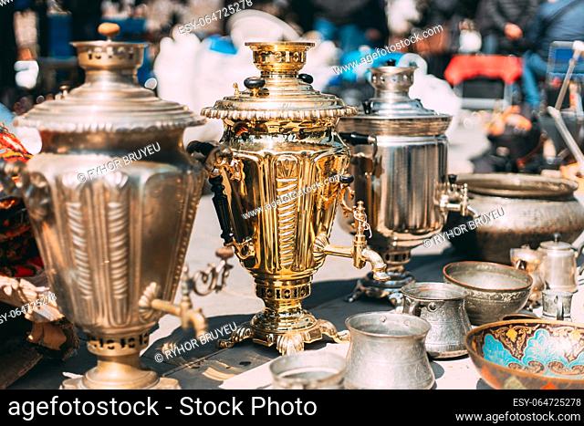 Shiny Bright Samovars Stand In A Row. Tea Party Concept And Hospitality. Traditional Russian Samovar At Flea Market. Vintage Copper Samovar
