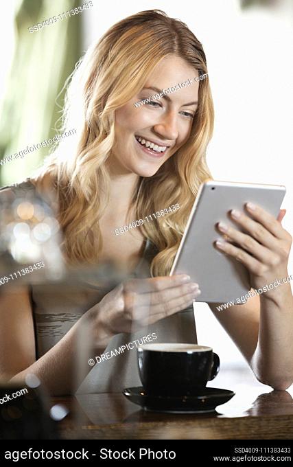 Caucasian woman using digital tablet in cafe