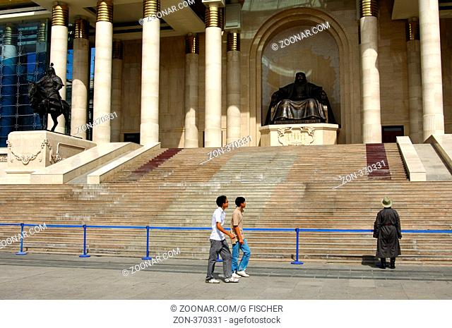 Fussgänger am Dschinghis Khan Denkmal am Parlamentsgebäude auf dem Suchbatar-Platz, Ulanbator. Mongolei / Bypassers at the Chinggis Khaan monument at the...