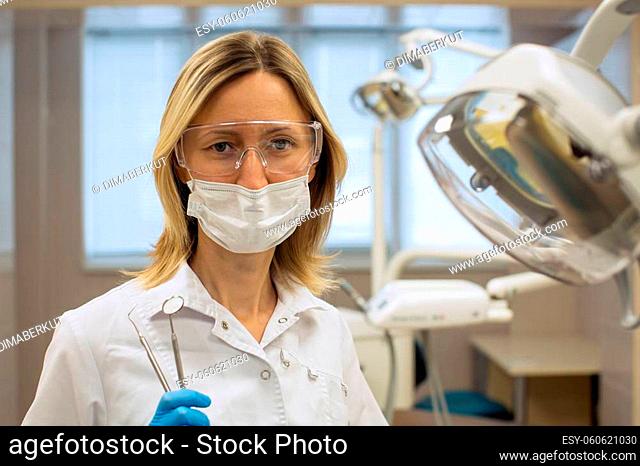 Female dentist portrait with medical office background. Medicine and stomatology concept