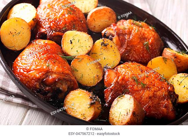 American Food: maple chicken thighs and baby potatoes close-up on a plate. horizontal