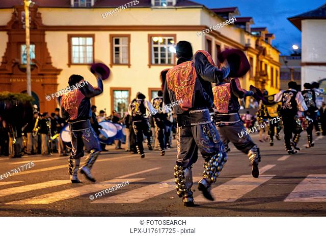 Puno: traditional street festa with formation dancing in ceremonial costume, evening, Peru