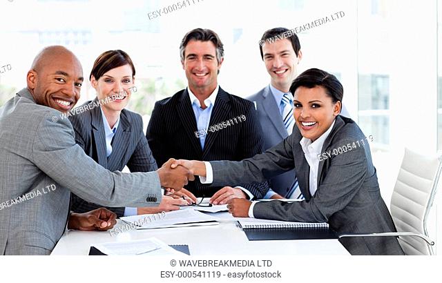 A diverse business group closing a deal in the office