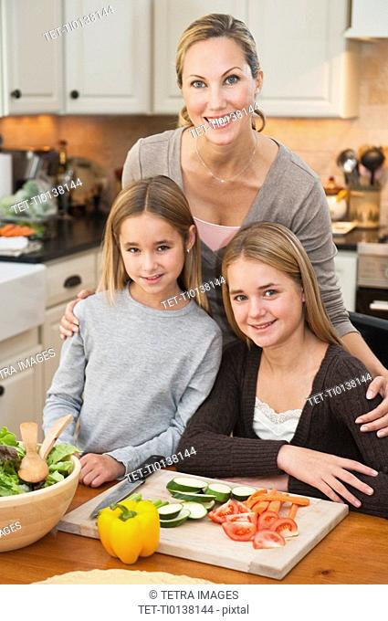 Mother and daughters making salad