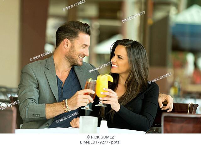 Couple toasting with cocktails at restaurant