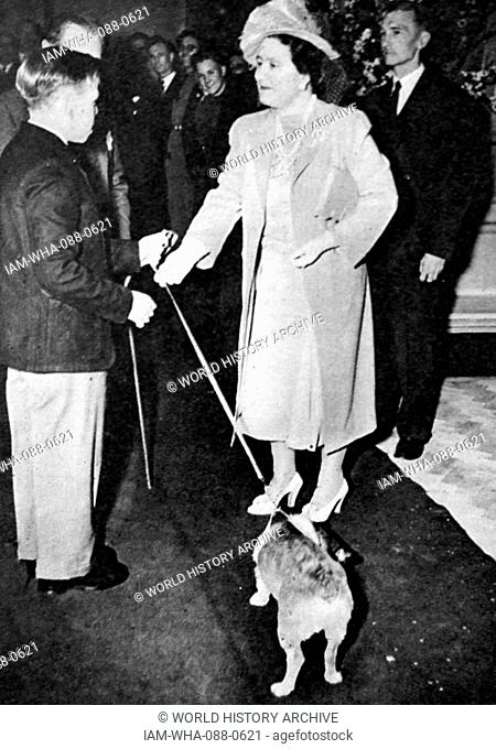 Photograph of the Queen Mother (1900-2002) receiving a corgi Dated 20th Century