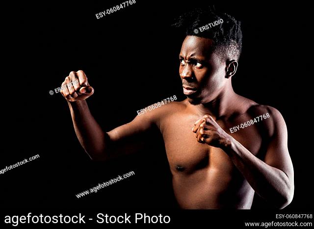 portrait of an African-American athlete man boxing on black background