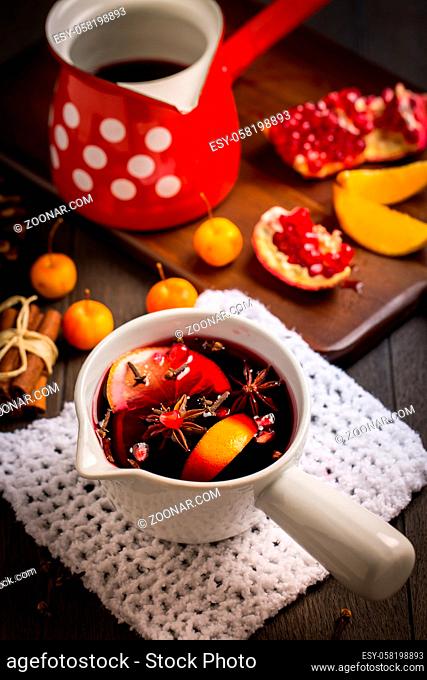 Hot spicy mulled wine with fruits and spices in mug for winter and Christmas