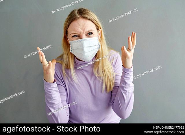 Angry woman wearing protective mask