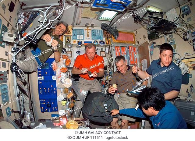 The STS-123 and Expedition 16 crewmembers share a meal near the galley in the Zvezda Service Module of the International Space Station while Space Shuttle...