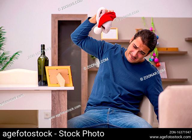 Young man celebrating new year alone at home