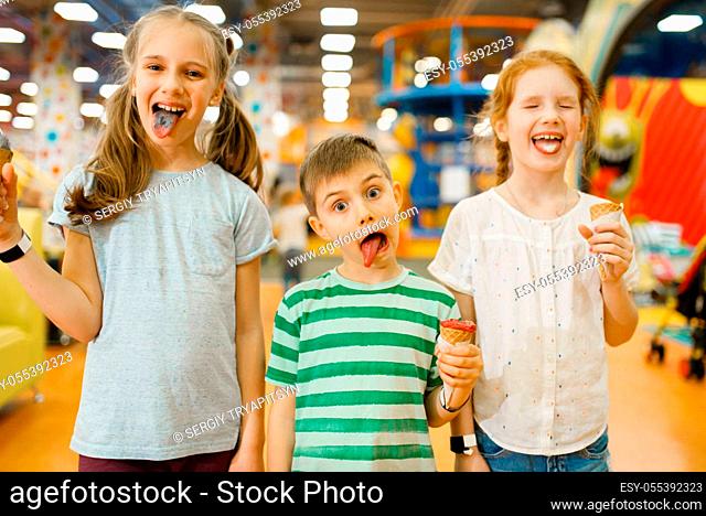 Children eats ice cream in the entertainment center. Boy and girls leisures on holidays, childhood happiness, happy kids on playground