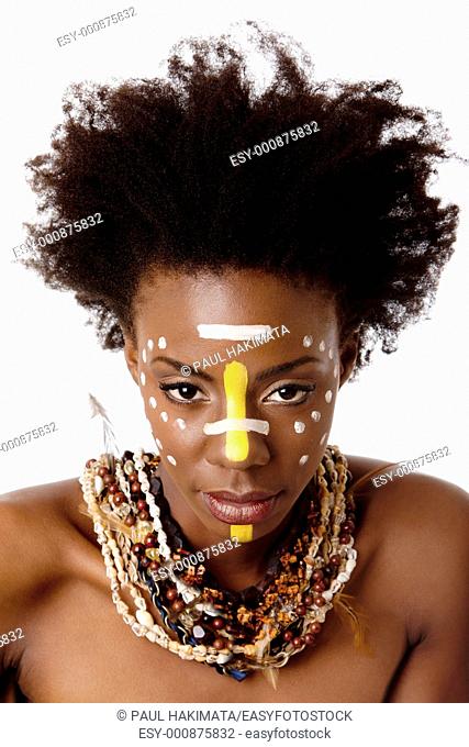 Beautiful head of an African tribal woman with Afro curly hair, face paint dots stripes, bare shoulders and smooth brown skin wearing Earth-tone bead shell...