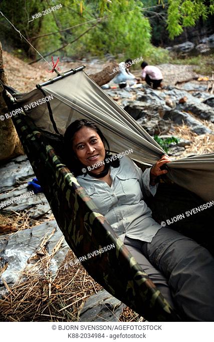 Tourists sleeping in hammocks along the O Chbar river. Dey Ei Trek, Mondulkiri, Cambodia