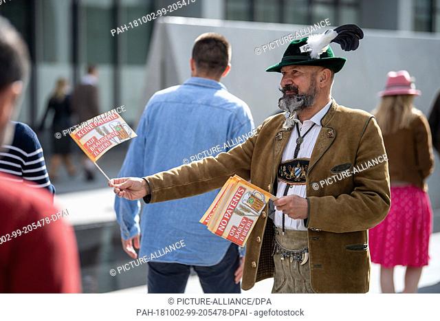 02 October 2018, Bavaria, Munich: Demonstrators against the patenting of bred plants and animals, distributing leaflets and flags before the European Patent...