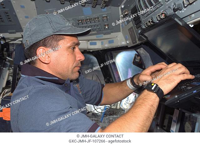 Astronaut William A. (Bill) Oefelein, STS-116 pilot, uses a computer on the flight deck of Space Shuttle Discovery during flight day two activities