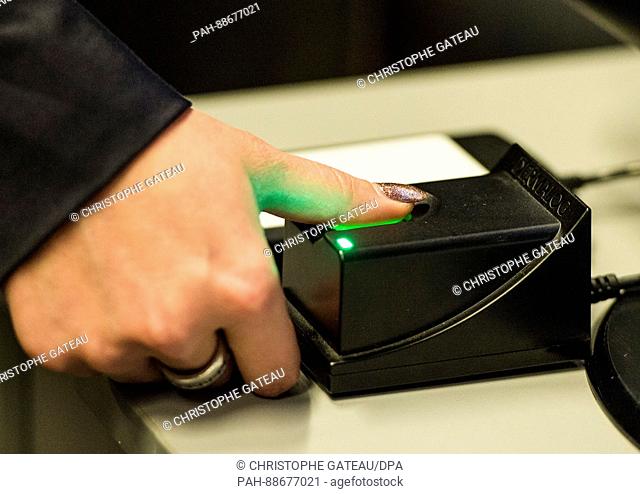 A woman demonstrates the usage of a fingerprint scanner during a press call of the German Slot Machine Association (Deutsche Automatenwirtschaft) in Berlin